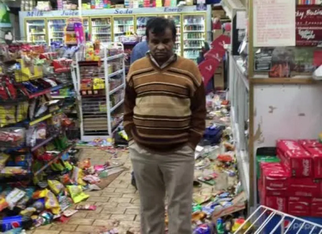 A store owner looking through his looted store