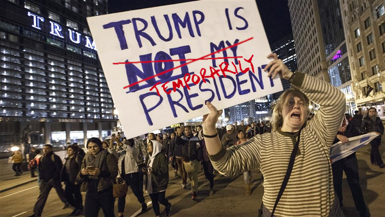 Woman with conflicted sign about whether Trump is President